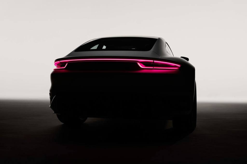 A car silhouette on a dark surface with a coral rim light along its edge.