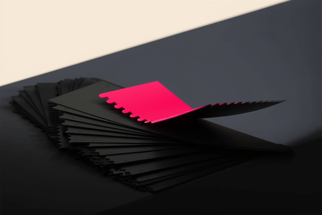 Paint swatches on a dark surface with one coral swatch in focus.