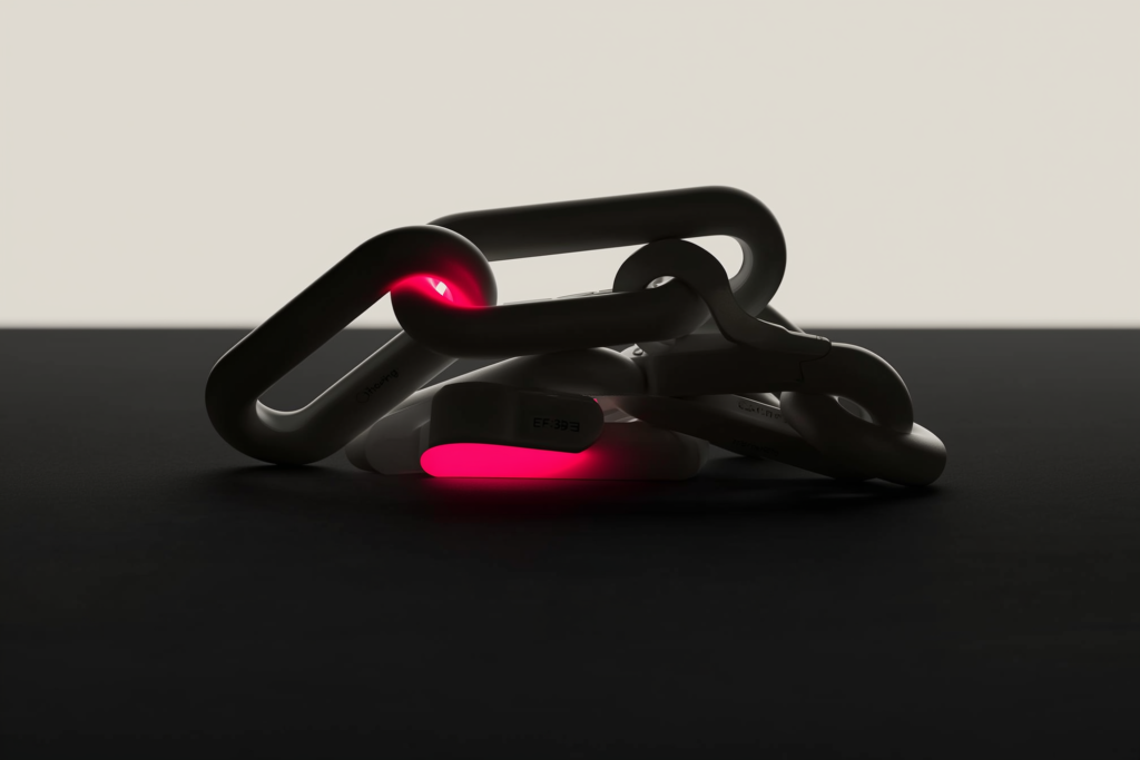 Interlocking chain links with one glowing coral link on a dark surface.