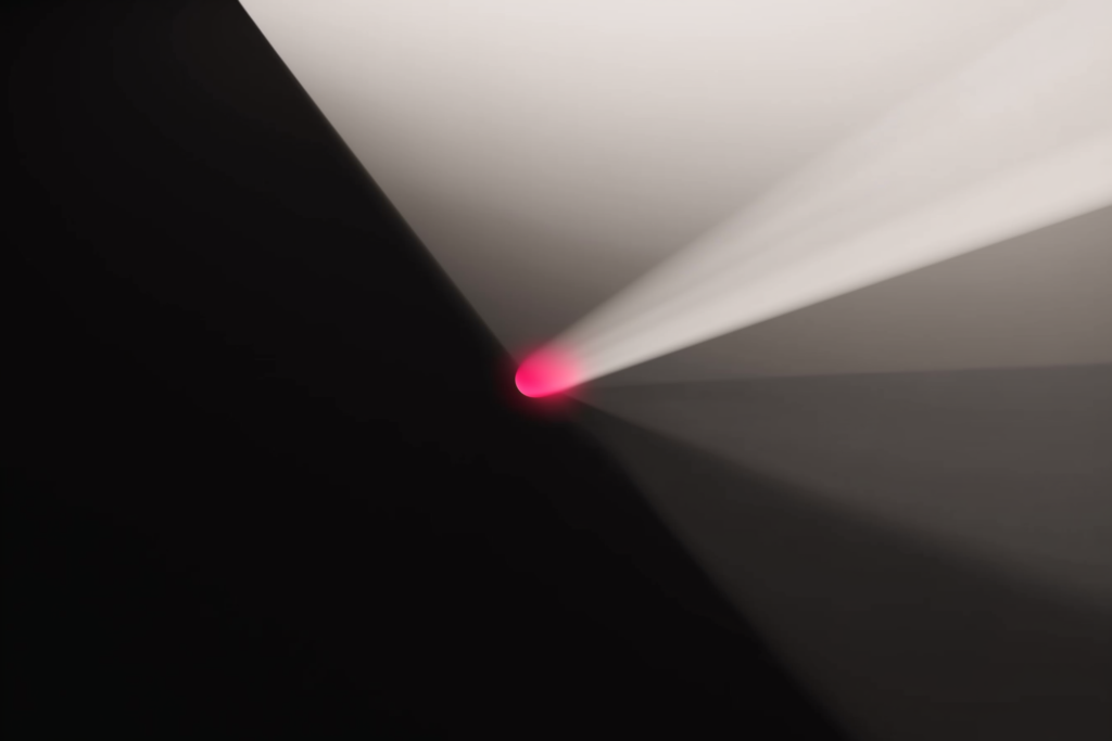 A coral beam fanning into many channels on a dark surface.