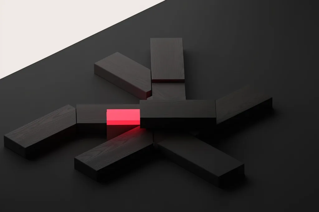 Wooden blocks in a branching structure on a dark surface, one glowing coral.