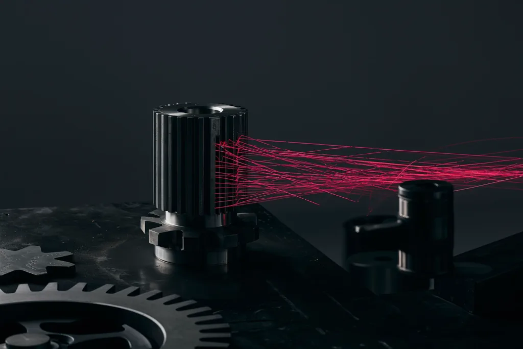 A machined gear on a dark surface with a coral network of light radiating out.