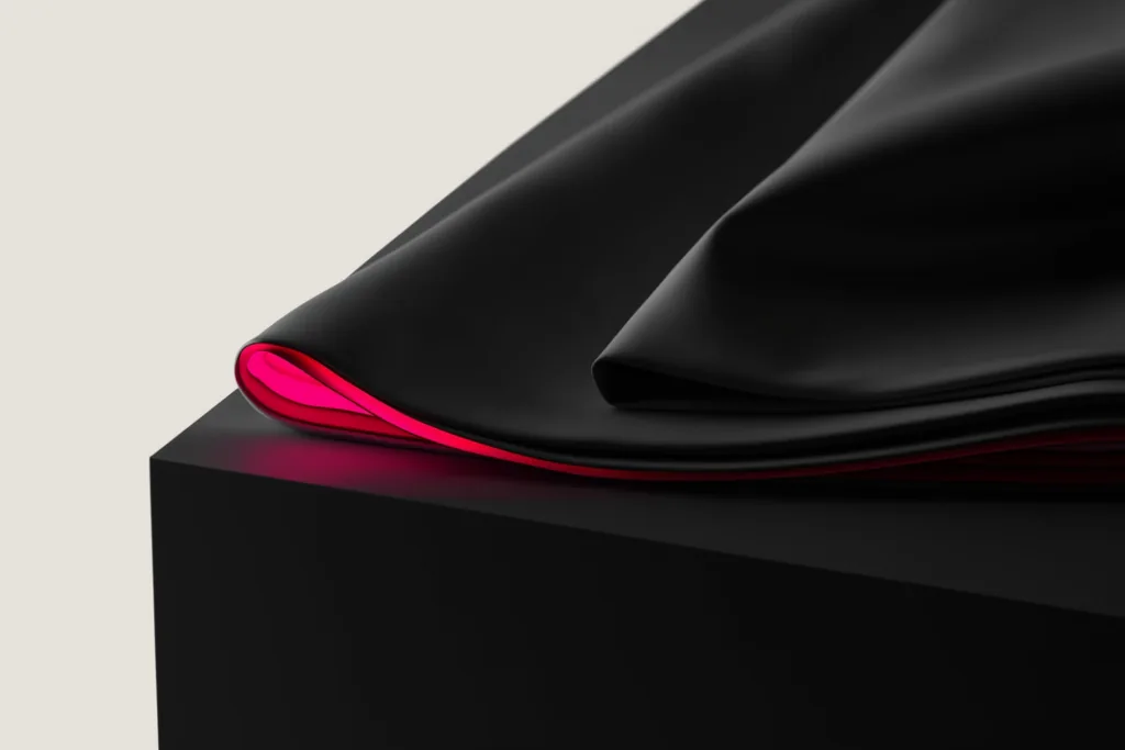 Folded premium fabric on a dark surface with a coral accent edge.