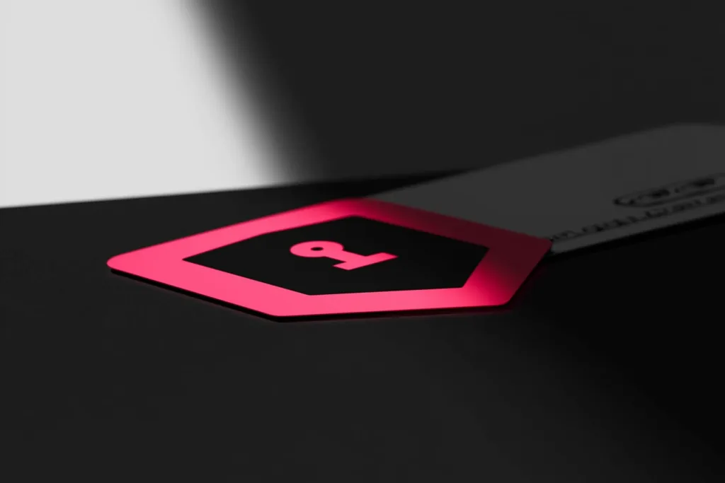 A coral shield of light over a coin/card on a dark surface.