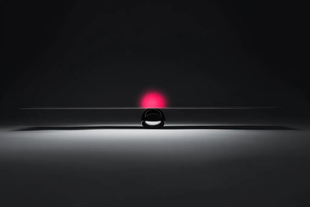A balance scale of light with a coral glow at the centre on a dark surface.