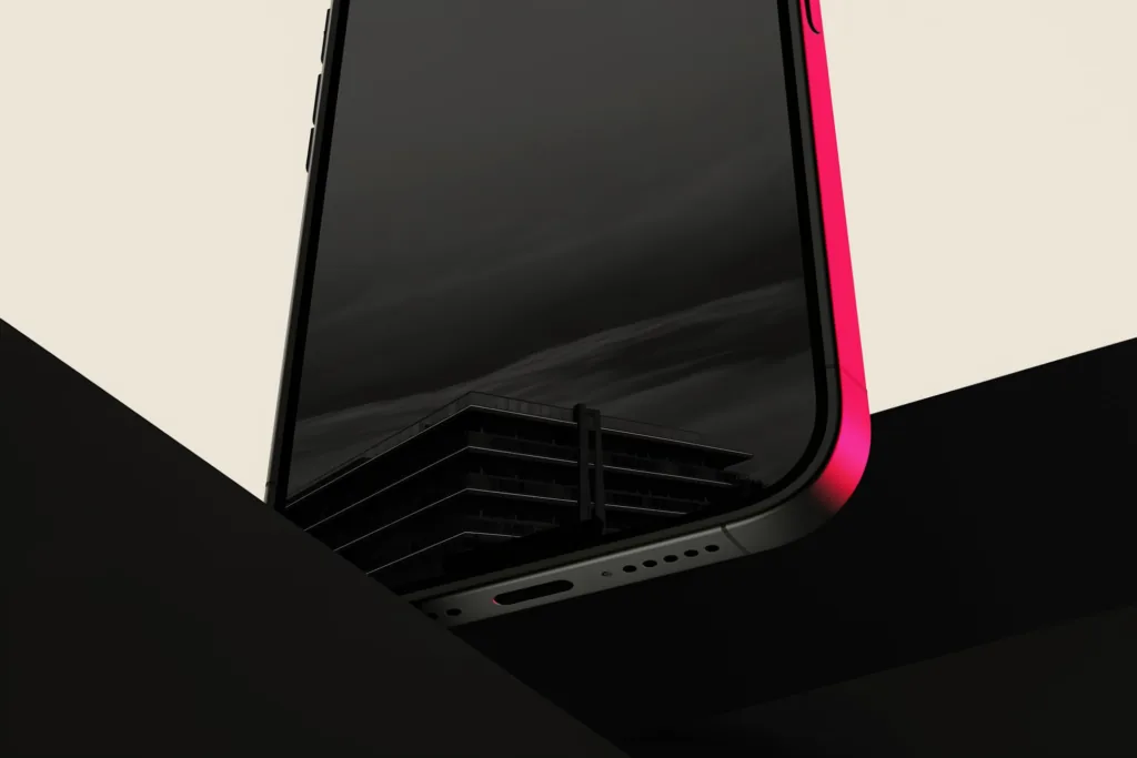 A phone framing a glowing building, screen edge lit coral, on a dark surface.