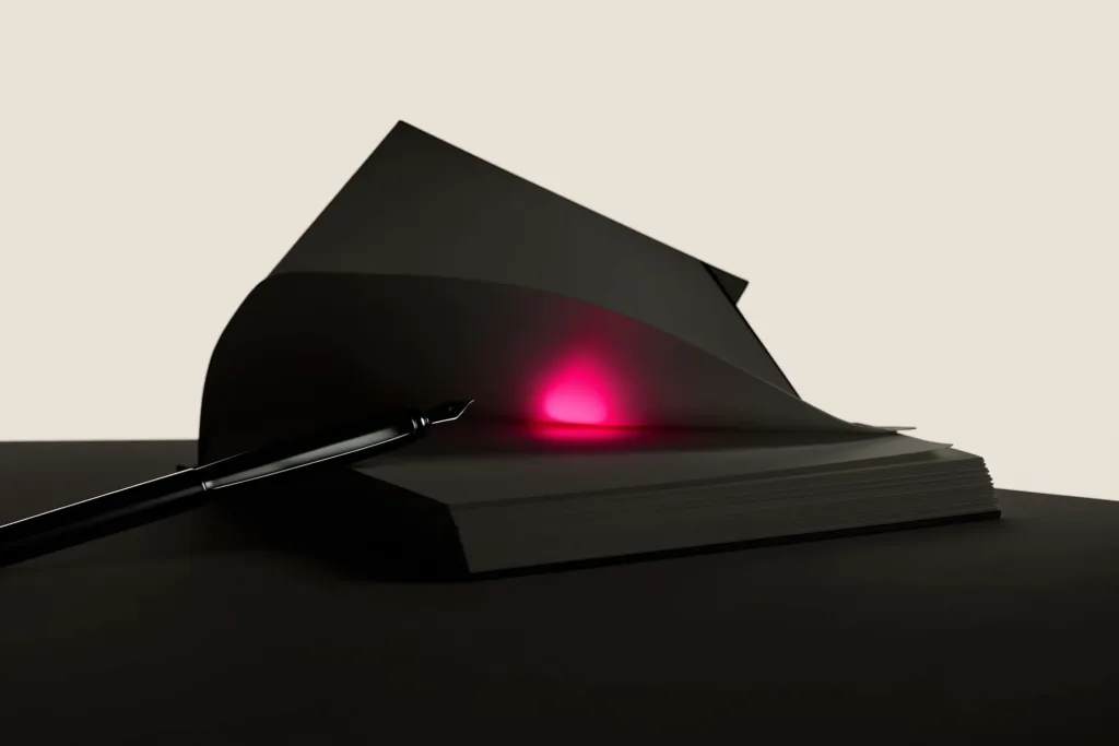 An open notebook on a dark desk with one line glowing coral.