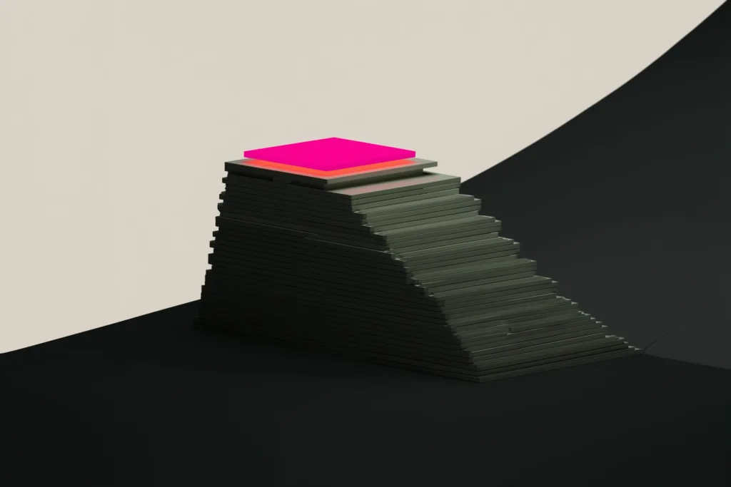 A compounding stack of tiles topped by a coral tile on a dark surface.
