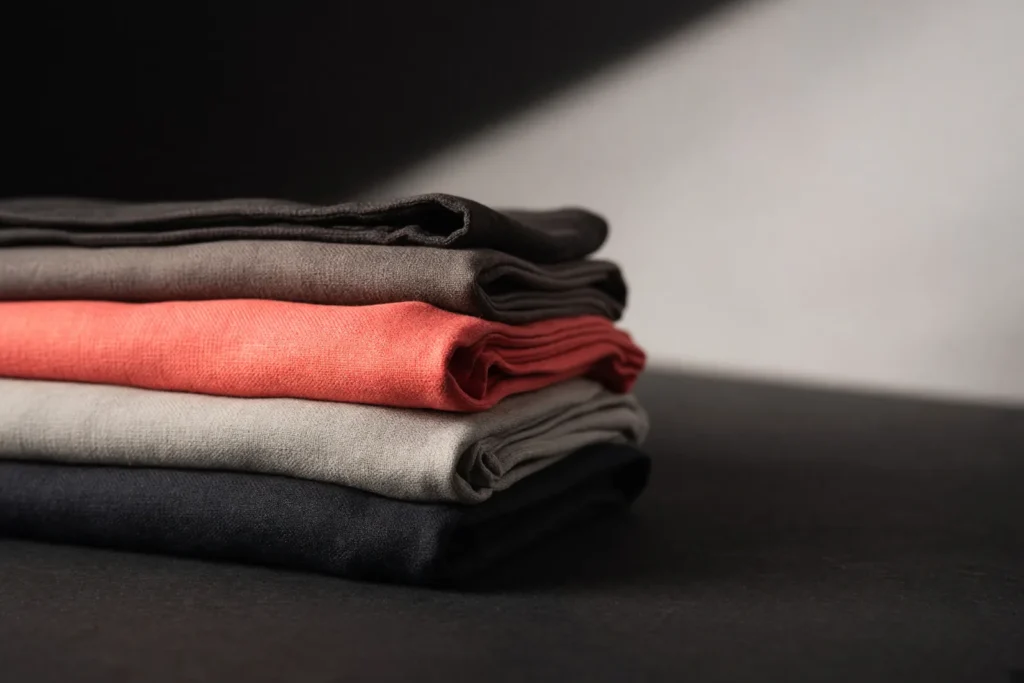 Folded fabric bolts with one bolt in vivid coral pink.