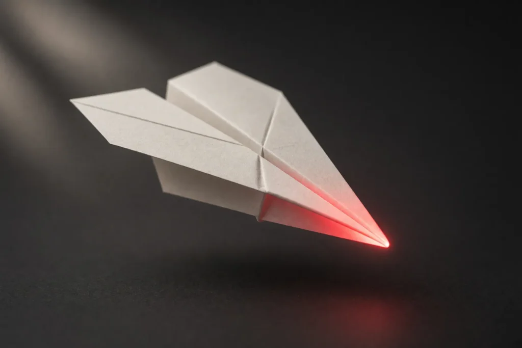 A paper plane folded from a blank sheet, its tip glowing coral pink.
